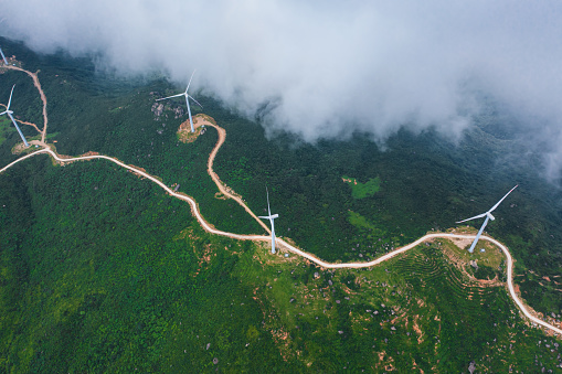 Aerial view of Wind turbines, windmill, farm, agricultural fields at sunrise sunset. Rural landscape. Renewable green energy concept, dawn dusk sky