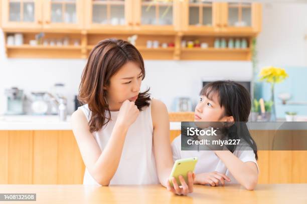 Asian Mother And Daughtersmart Phone Think Stock Photo - Download Image Now - Mother, Worried, Child