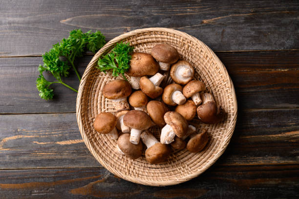 istock Fresh shiitake mushroom in basket on wooden background 1408133355