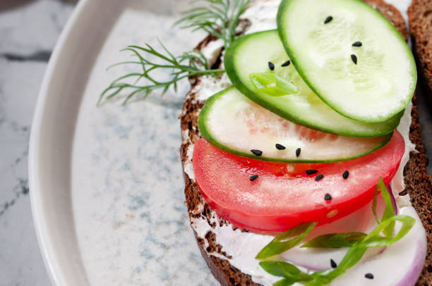 Breakfast, sandwiches with vegetables, prosciutto and cheese, close-up