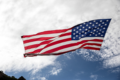 Closeup of a Large American flag hanging across a mountain valley