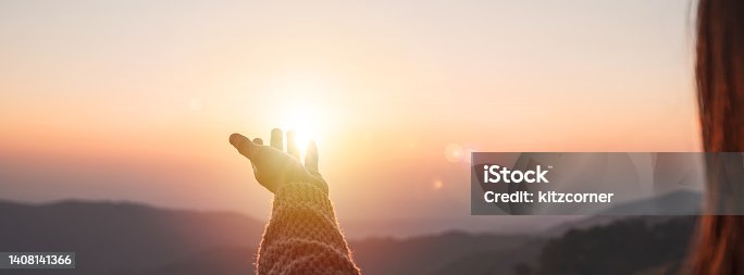 istock Young woman hand reaching for the mountains during sunset and beautiful landscape 1408141366