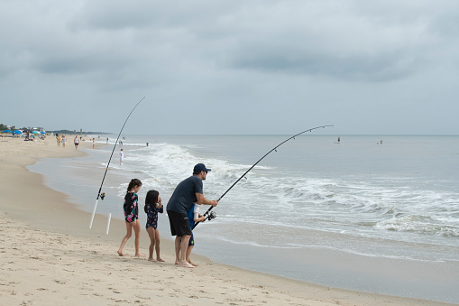 Rehoboth Beach, USA - July 3, 2022. Father with three children fishing at Rehoboth Beach, Delaware, USA
