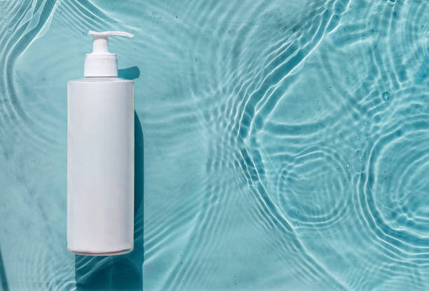 istock Cosmetic moisturizer with hyaluronic acid, micellar emulsion on blue water background with splashes. Mockup of cosmetic packaging 1408148716