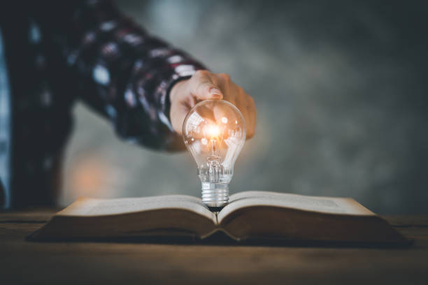 istock light bulb, Hand holding illuminated light bulb, innovation inspiration concept, Book or textbook with brainstorming glowing light bulb. 1408149598