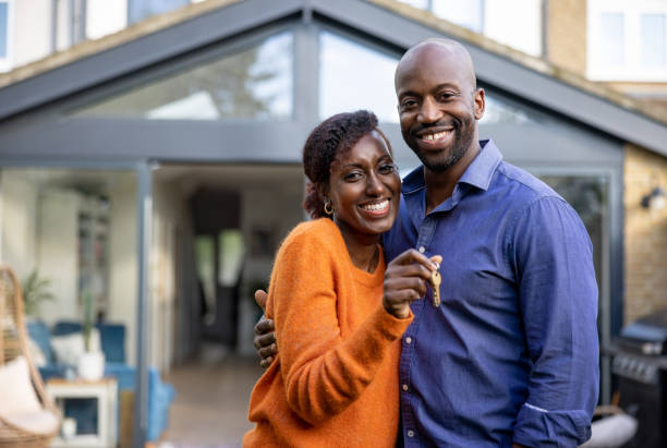 feliz pareja negra sosteniendo las llaves de su nueva casa - recién casados fotos fotografías e imágenes de stock