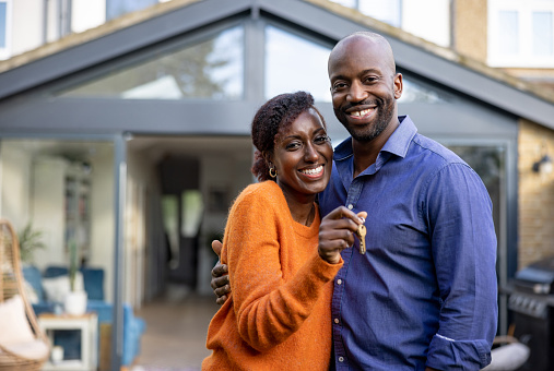 Happy black couple holding the keys of their new house