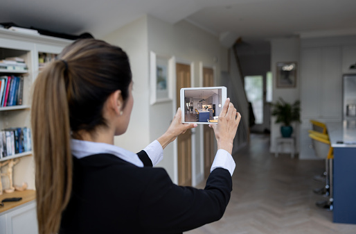 Real estate agent making a virtual tour of a house using a tablet - real estate showing concepts
