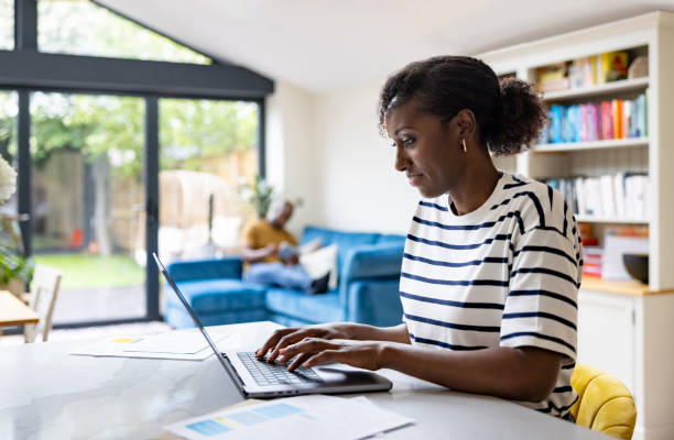 Happy black woman working at home on her laptop