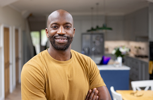 Portrait of a happy African American man smiling at home and looking at the camera - domestic life concepts