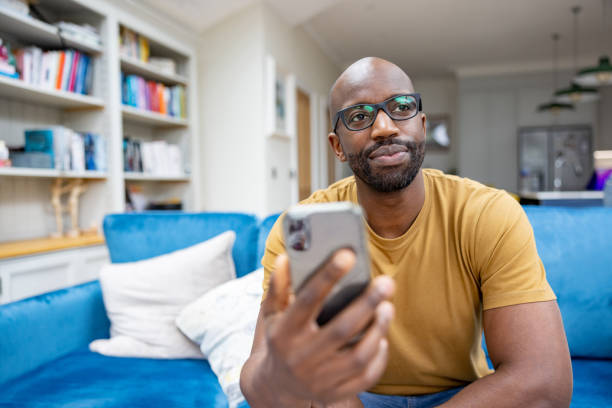 istock Man at home using a mobile app on his cell phone 1408150711