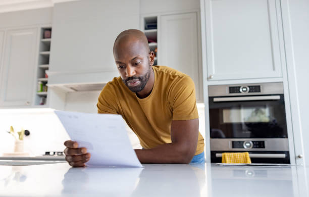 istock Man at home reading a letter in the kitchen 1408150729