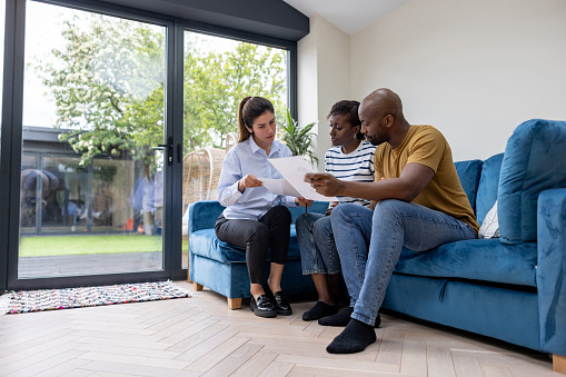 Couple buying a house and reviewing the contract with their real estate agent