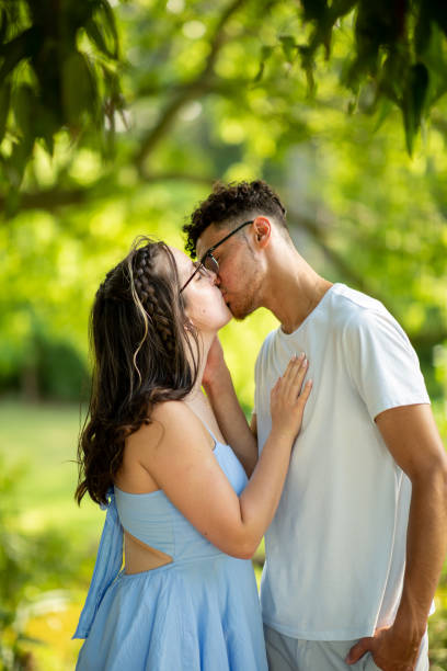 istock Interracial Couple Kissing at a Park 1408151788