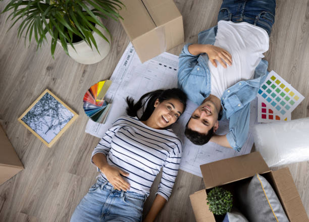 istock Happy couple moving into their new house and having fun decorating it 1408152468