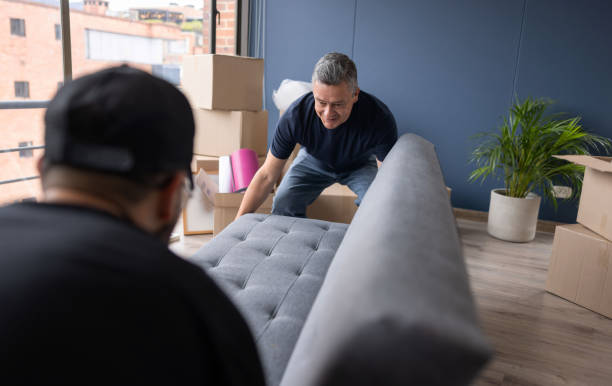 Professional movers carrying a sofa out of an apartment Professional movers carrying a sofa out of an apartment - moving house concepts Moving Service stock pictures, royalty-free photos & images