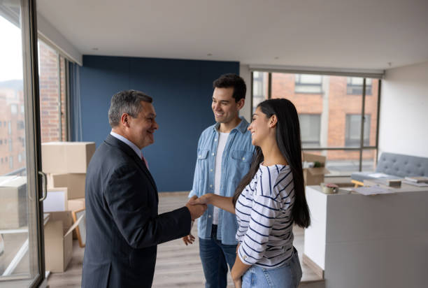 Real Estate Agent selling an apartment to a couple and closing the deal with a handshake Real Estate Agent selling an apartment to a couple and closing the deal with a handshake - real estate concepts tenant stock pictures, royalty-free photos & images