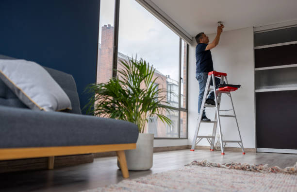 istock Electrician fixing a light bulb at an apartment 1408152933