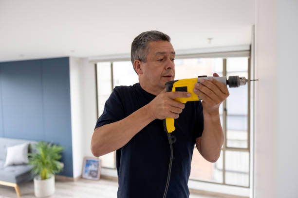 istock Handyman drilling a hole in the wall at an apartment 1408152940