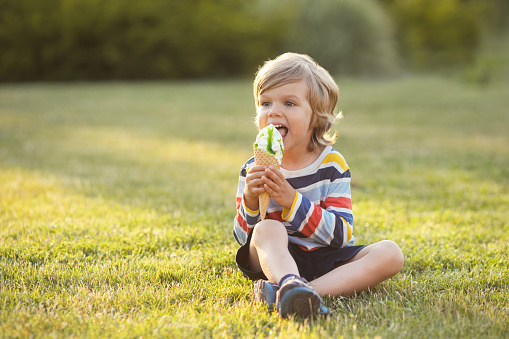 Group of children having fun licking ice cream cone in the yard