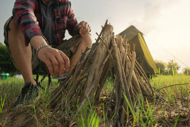 istock A man tourist making bonfire and set camping tent. 1408159240