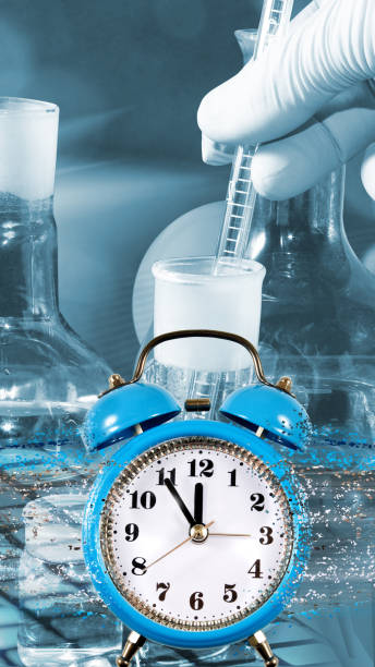 istock image of an alarm clock, from which particles break off, forming a stream. Dispersion of time and laboratory supplies on blue background 1408159391