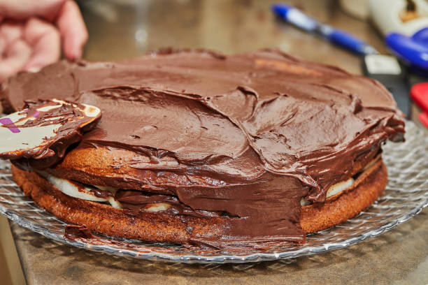istock Chef coats the cake with chocolate ganache to make chocolate cake with pears and walnuts 1408161264