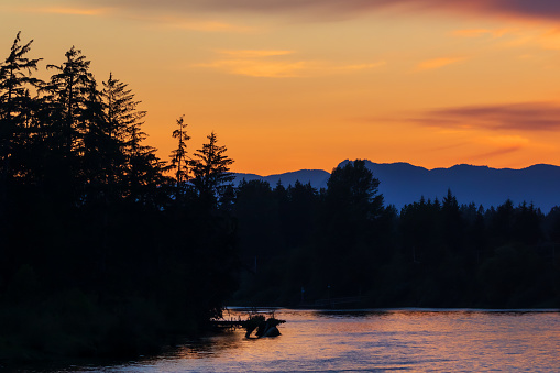 A group of kayakers kayaking on the open calm still ocean during sunset on a beautiful calm evening on the Sunshine coast, in British Columbia, Canada