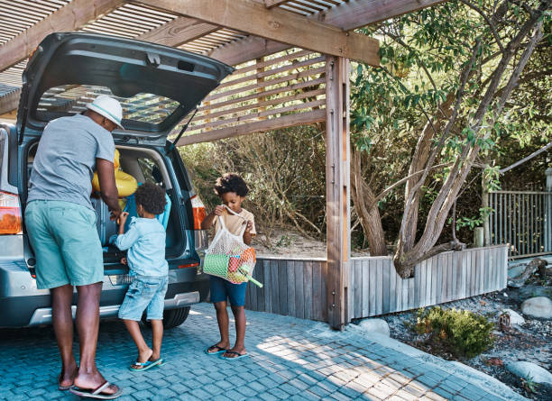 istock Black family packing car before leaving for a fun vacation. Single father getting ready to spend some family time his young kids, preparing for a fun adventure together. Family having a fun roadtrip 1408161784