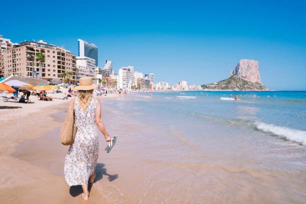 istock Woman walking on beach in Calpe , Spain 1408165894