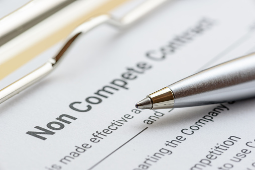 Legal concept : Blue ballpoint pen on a non compete contract. Noncompete contract is an agreement between employee and employer, not to enter into competition in subsequence business effort.