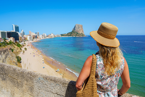 Woman looking at Ifach rock and Calp beach in Spain