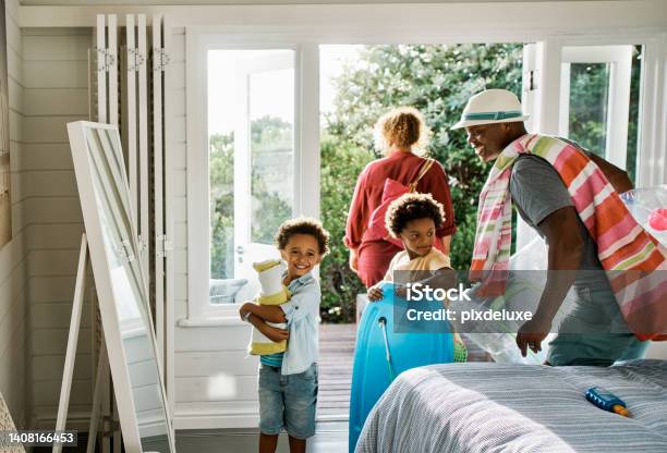 Black Family Getting Ready To Go To The Beach Father Mother And Two Sons Excited To Head Out On A Holiday Or Vacation Getaway Sibling Brothers And Their Parents With Towels And Toys For An Outing Stock Photo - Download Image Now