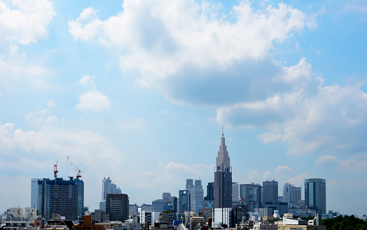 View of Tokyo Shinjuku skyline against cloudscape with copy space.
