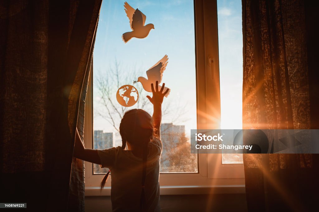 child stretches his hands sunlight outside window flying dove world with branch forces globe. concept peace world, no war, ecology child stretches his hands sunlight sunset outside window flying dove world with branch forces globe. concept peace world, no war, ecology, protection planet Earth, pacifism Hope - Concept Stock Photo