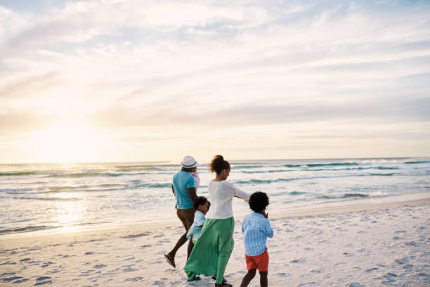 istock A family bonding while walking on the beach during fun summer vacation and getaway together. Loving parents bonding with their little kids and enjoying a weekend break to travel 1408170004
