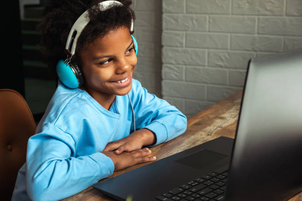 istock African-American girl doing homework,making notes,using headphones and laptop at home.Back to school concept.School distance education at home,home schooling,e-learning,diverse people 1408170984