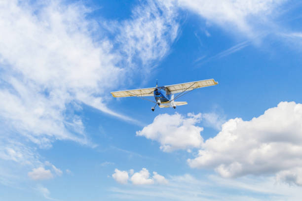 istock Light aircraft flying over blue sky 1408172707