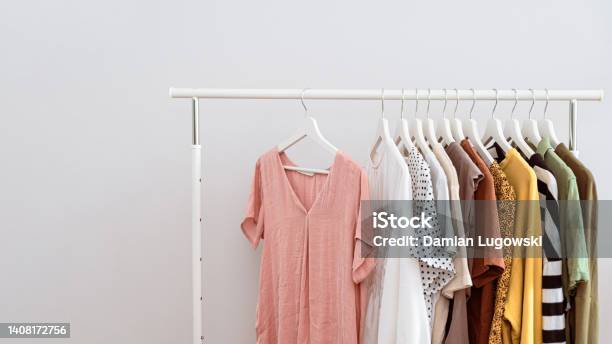 Womens Clothes Hanging In Row On White Coat Hangers Many Clothes Hangers On Portable Clothing Rack Stock Photo - Download Image Now