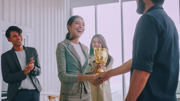 an employee of the company is proud to receive an award for a successful project. - entregando prêmios imagens e fotografias de stock