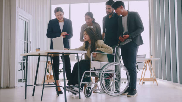istock A disabled company employee is explaining a computer program to a group of colleagues. 1408174027