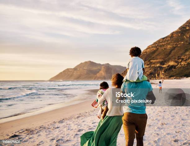 African Parents With Little Kids Bonding And Strolling By Ocean Little Children Enjoying The Outdoors During Their Summer Holidays Or Vacation Rear Of A Family Walking On The Beach With Copy Space Stock Photo - Download Image Now