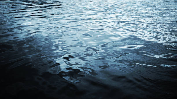 istock Black blue white water surface. Ripples. Reflection of light. Small waves. Background with space for design. 1408176054