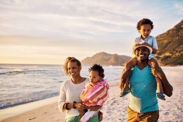 istock A family walking on the beach at sunset while relaxing during a fun summer vacation and getaway. Loving parents bonding with cheerful little kids and enjoying a weekend of travel 1408176080