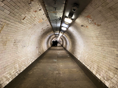 London in the UK in June 2022. People walking through the tunnel under the Thames at Greenwich