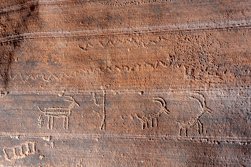 Native American petroglyphs carved into a cliff wall deep inside the Buckskin Gulch slot canyon near Kanab, Utah, USA.