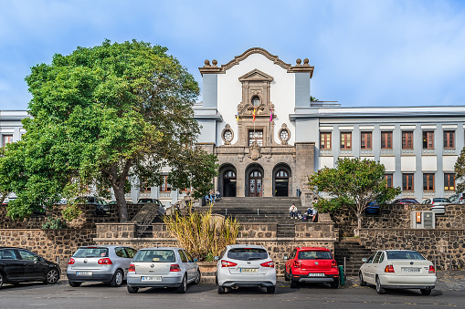 San Cristobal de La Laguna, Spain - November 24, 2021: Main campus of the University of La Laguna. Modern cars parked at the stairs to an ancient building in the Canary Islands