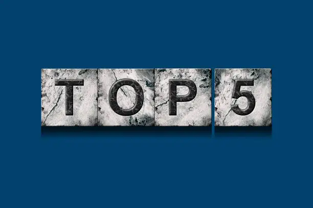 Photo of Top 5, words, on a dark blue background. Isolated. Alphabet on stone blocks.Rating. Rating concept.