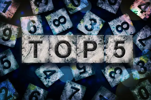 Photo of Top 5, words, above different numbers, on a dark blue background. Alphabet on stone blocks.Rating. Rating concept.