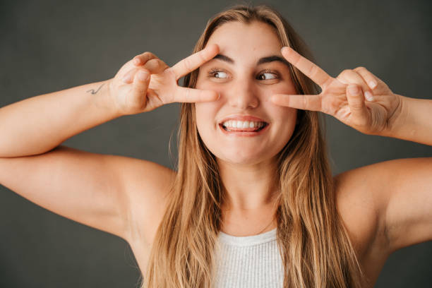 istock Close up Fun loving female making peace sign the studio 1408183435